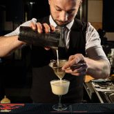 Bartender pouring a cocktail during a birthday masterclass at The Sugar Cane bar in Clapham, London