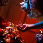 Group of friends toasting with champagne glasses at a London birthday party in a cocktail bar