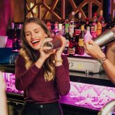 Guests laughing and shaking cocktails during a cocktail masterclass at The Sugar Cane Bar in Clapham, London.