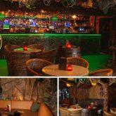Interior of Sugar Cane Bar in London featuring tiki decor, bamboo furniture, glowing green bar lighting, and cosy seating areas perfect for group celebrations and themed parties