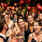 Group of friends celebrating a private party at a vibrant London bar with red heart balloons and festive lighting
